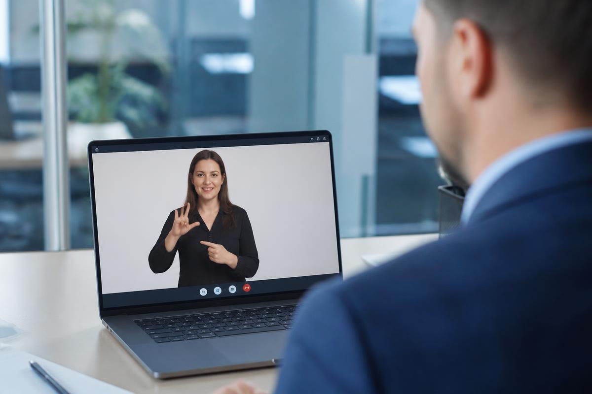 Business professional in a video remote interpretation session with a sign language interpreter on screen